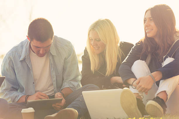 istock Group of young people using technology in the park. 467128592