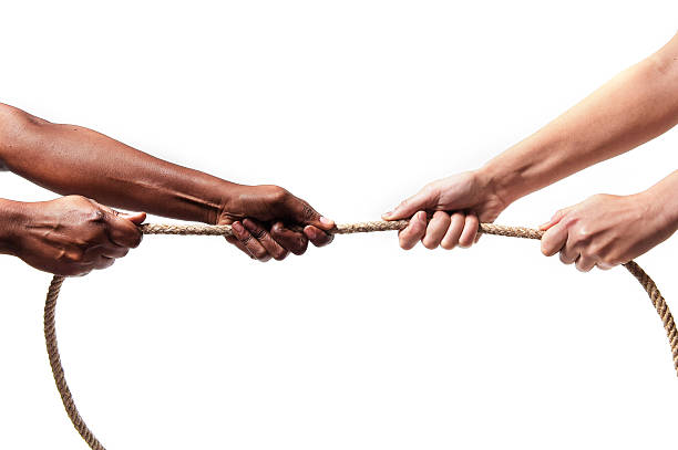 istock black ethnicity hands pulling rope against white Caucasian race person 467128758