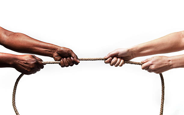 istock black ethnicity hands pulling rope against white Caucasian race person 467128760