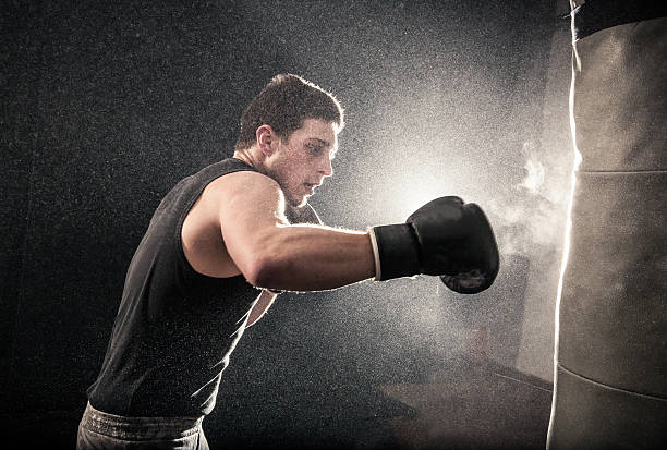 istock Young man with boxing gloves on hitting a punch bag 467131958