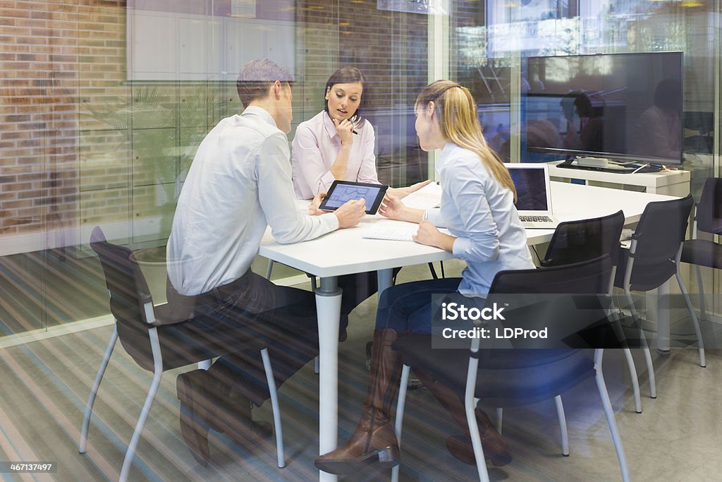 Business team studying a tablet PC at meeting Businesswoman businessman reunion laptop desk colleagues Office Stock Photo
