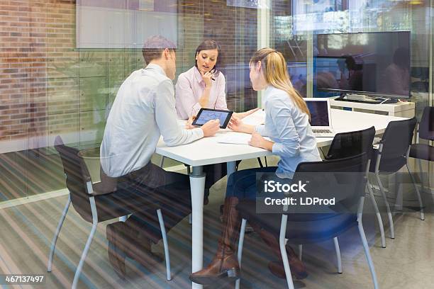 Business Team Studying A Tablet Pc At Meeting Stock Photo - Download Image Now - Office, Three People, Bank - Financial Building