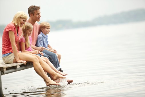 A family sitting by a ledge looking over the river with copyspace