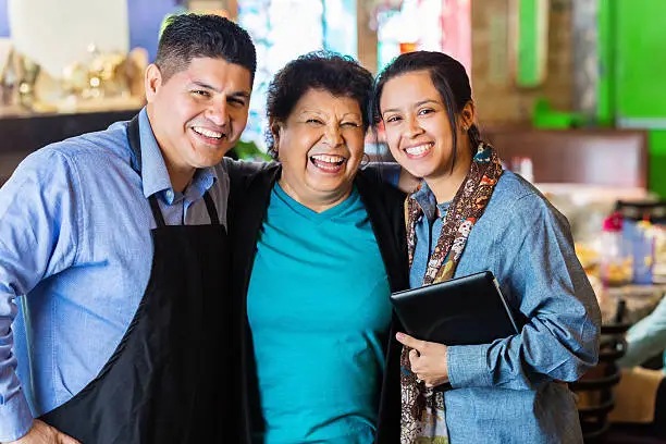 Photo of Hispanic grandmother, son and granddaughter in family owned restaurant