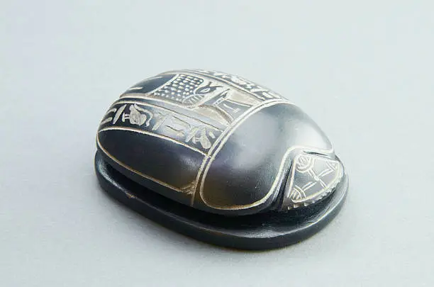 Beetle scarab out of Egypt on a gray background. Desktop statuette.