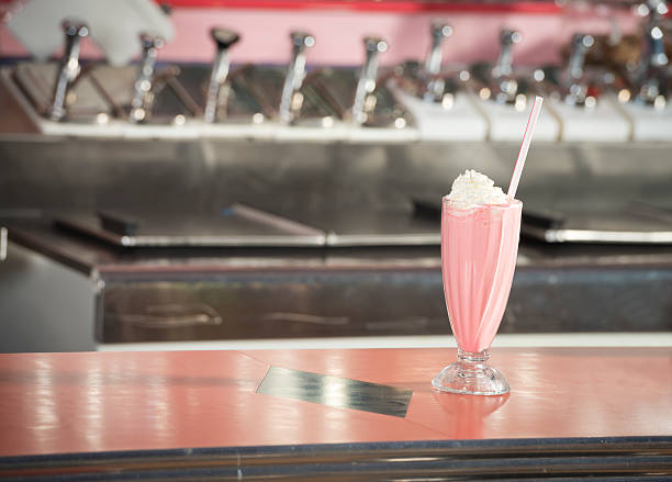 Strawberry Milkshake A strawberry milkshake sitting on a counter at a 1950's diner 1950s diner stock pictures, royalty-free photos & images