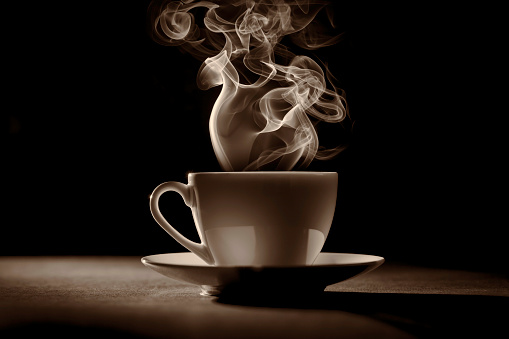 cup of coffee (or tea) with steam on black background 