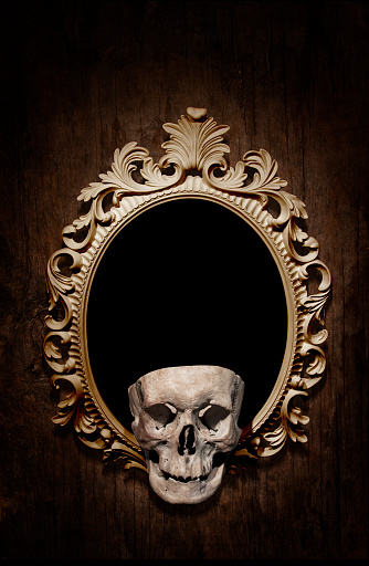 Human skull with ornate victorian frame against an old wooden background - perfect quotation frame