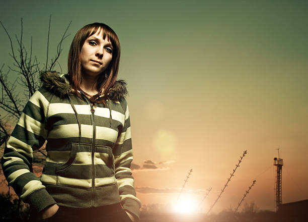 young girl looking into camera with sunset behind her