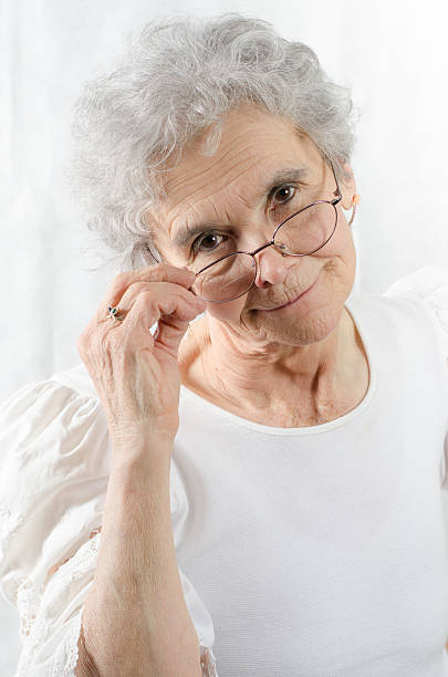 istock old woman is looking friendly over her glasses 467151110