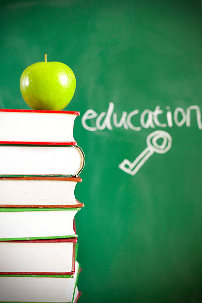istock education = key - written on blackboard with apple, books 467151334