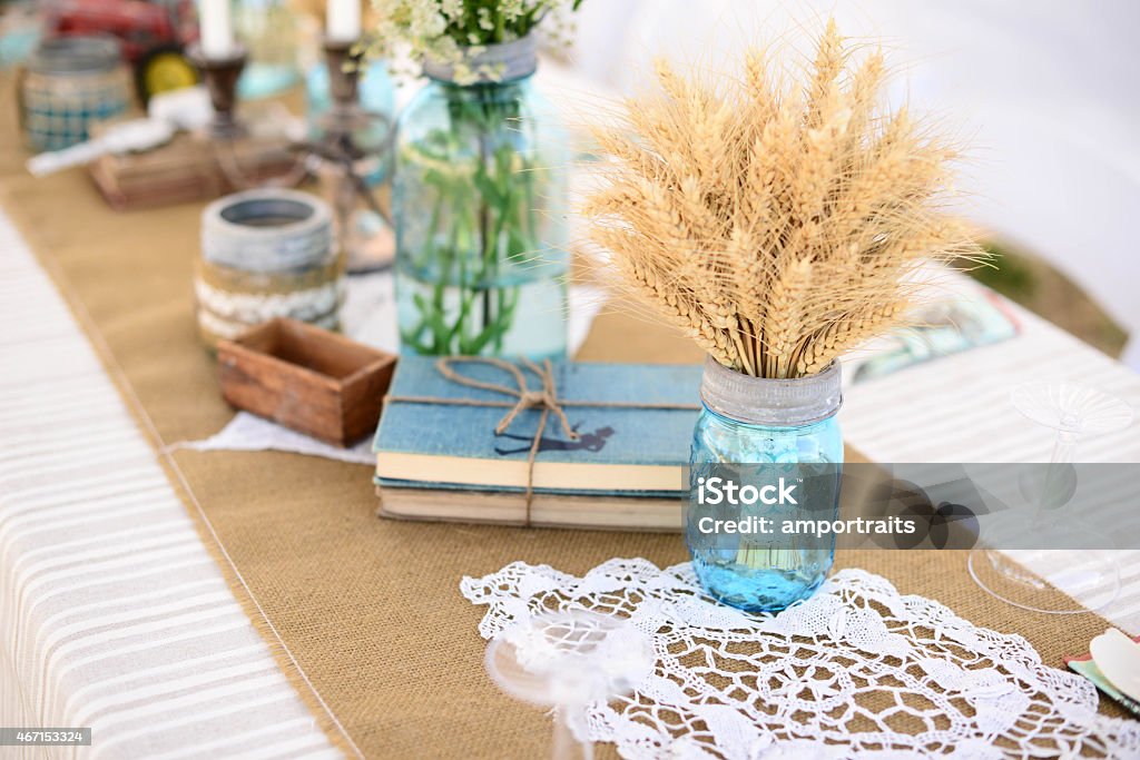 Rustic decor on table Rustic decor on table, including old books, wheat in mason jar, doily.  2015 Stock Photo