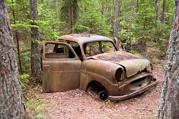 An old car dumped in a forest in Kirkoe Mosse stock photo