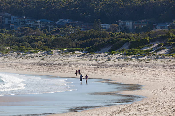 deux couples de marche sur la plage.  fingal'bay.  en australie - port stephens new south wales australia coastline photos et images de collection