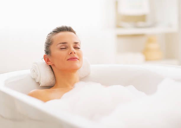 glückliche junge frau entspannung in der badewanne - relaxation women bathtub bathroom stock-fotos und bilder