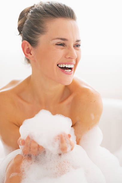 istock smiling young woman in bathtub with foam 467159717