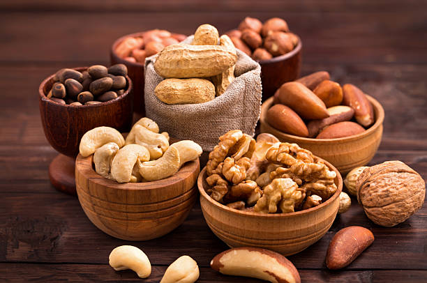 Bowls of various nuts Variety of nuts: walnut, hazelnut, cashew, peanuts,  pine nuts and other nut stock pictures, royalty-free photos & images