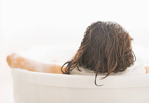 istock young woman relaxing in bathtub. rear view 467161271