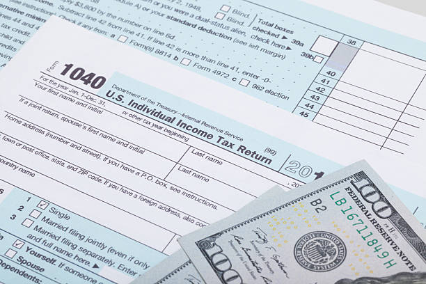 istock US 1040 Tax Form and dollars - studio shot 467177254