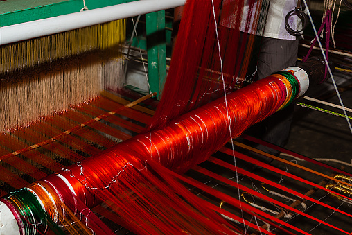 Brightly coloured silk threads going into a hand loom in the process of the making of a much sought after Kanchipuram Silk Sari (Indian lady's attire).  Photo shot in the city of Kanchipuram in Tamil Nadu, South India.  Horizontal format.  Close-up. no people.