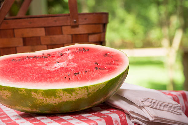 istock Food:  Fresh red ripe watermelon on traditional checked picnic tablecloth. 467180487
