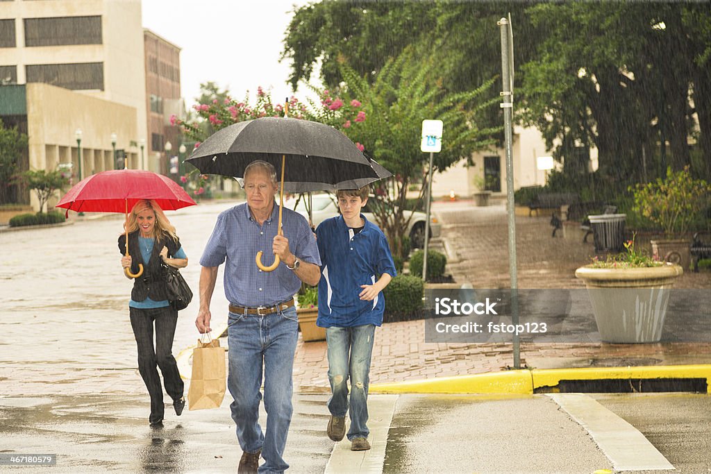Konsum: Menschen Einkaufsmöglichkeiten in der Innenstadt im Regen. Alle tragen Sonnenschirmen. - Lizenzfrei Amerikanisches Kleinstadtleben Stock-Foto
