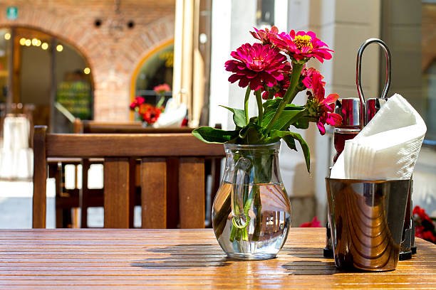 table at a outdoor restauran  with flowers and napkins