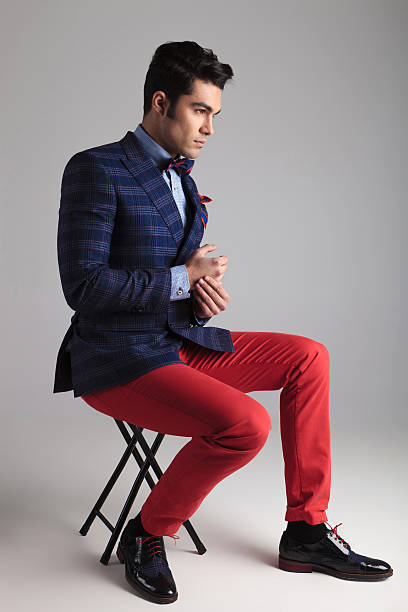 istock young casual man sitting on a stool 467184322