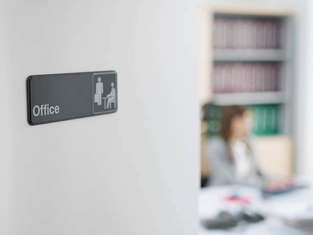 Office Sign with Worker in Background stock photo