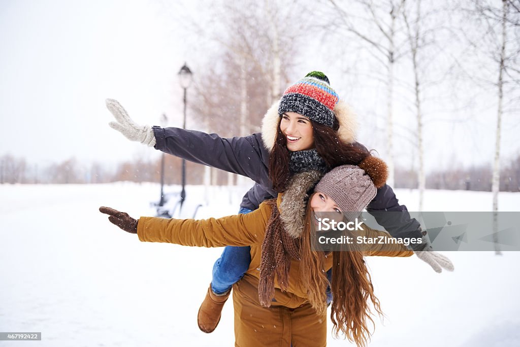 Wintertime merriment Shot of two female friends enjoying a snowy day outside Parka - Coat Stock Photo