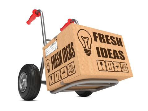 Fresh Ideas Slogan on Cardboard Box on Hand Truck White Background.