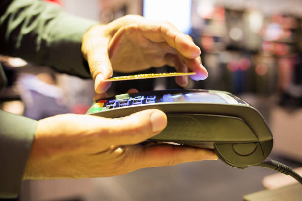 istock Man uses NFC reader and credit card to pay in store 467194463