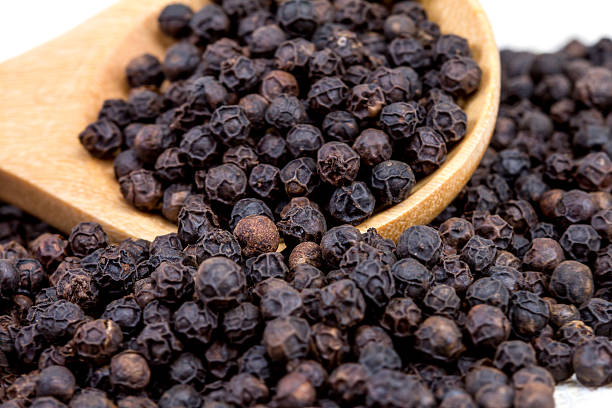 istock closeup black pepper in wooden spoon on fabric 467196408
