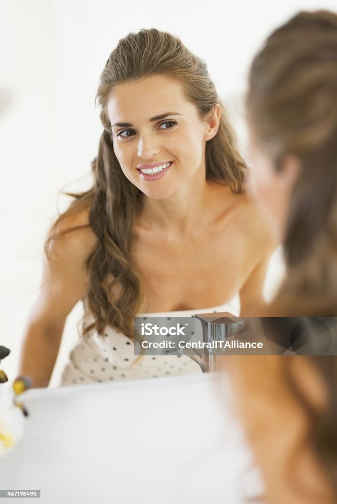 happy young woman looking in mirror Happy young woman looking in mirror Adult Stock Photo