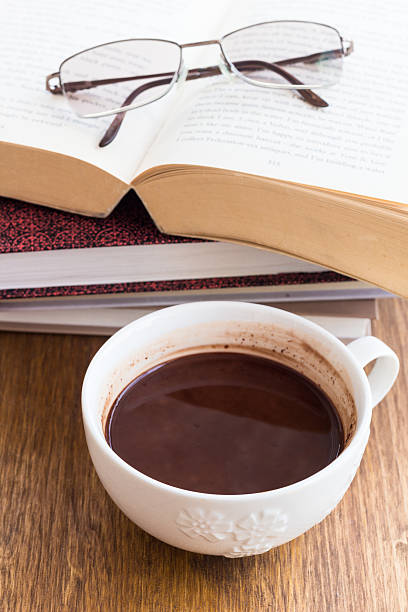 Cup of chocolate on a wooden table with books