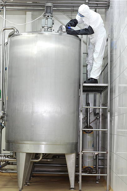 istock Technician closing large industrial process tank in factory 467204201
