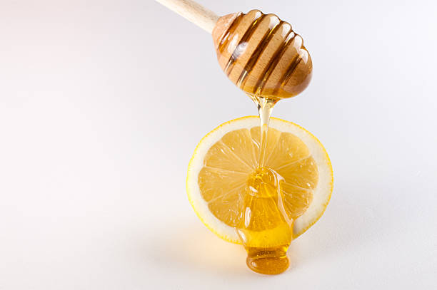istock honey dripping on slice of lemon isolated white 467205576