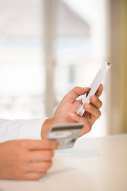 istock Woman's hands holding credit card and using cell phone 467207847