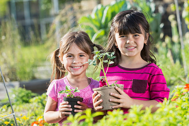 Mother putting headscarf on her daughter in a tropical garden