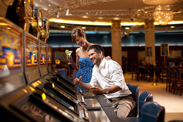 feliz slot machine a tocar - casino worker imagens e fotografias de stock