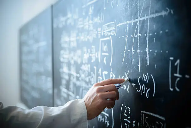 A scientist in front of a blackboard filled with formulas and equations