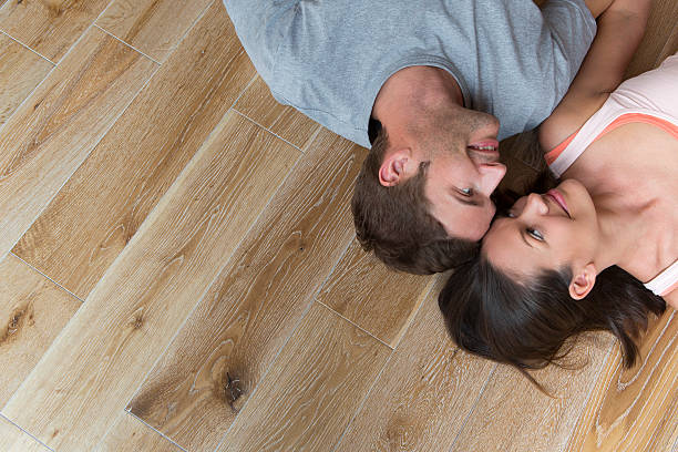 istock Couple lying on hard Wood Floor 467212405