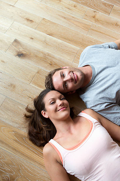 istock Couple lying on hard Wood Floor 467212437