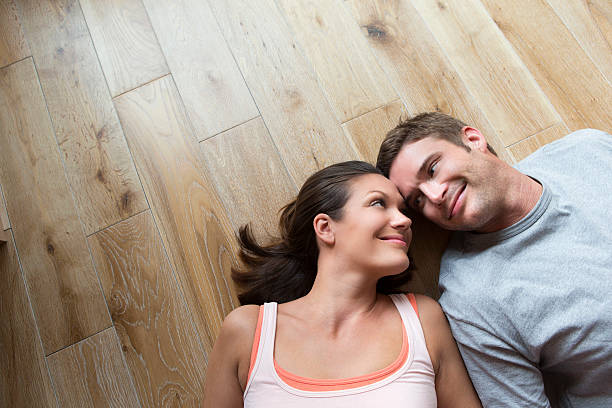istock Couple lying on hard Wood Floor 467216525