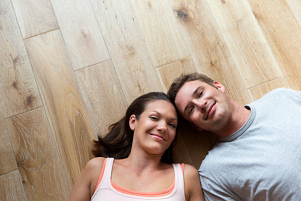 istock Couple lying on hard Wood Floor 467216533