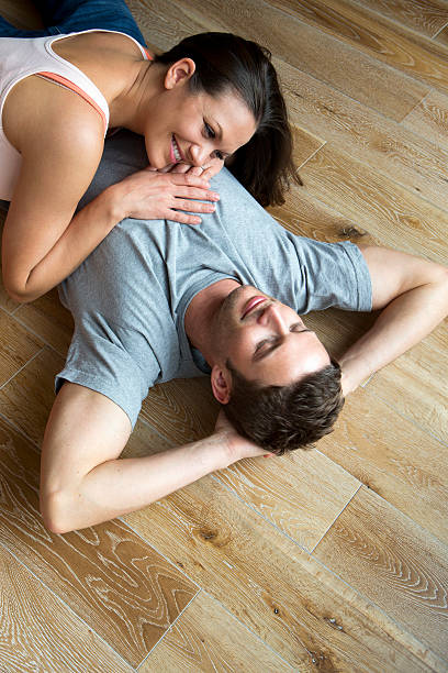 istock Couple lying on hard Wood Floor 467216583