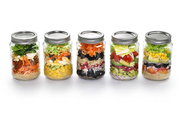 istock vegetable salad in glass jar, white background 467216584