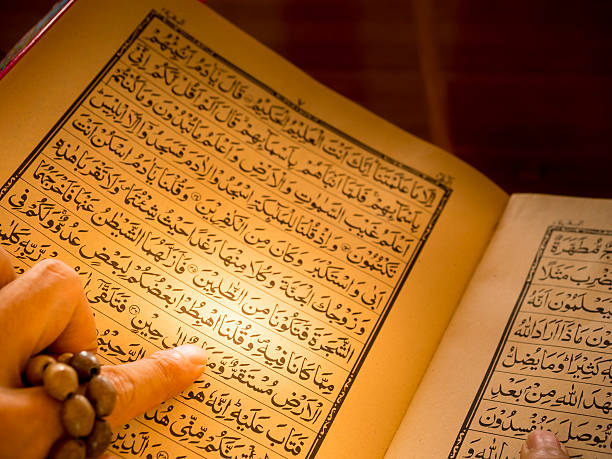 istock muslim man's hand reading Quran, holy book 467220676