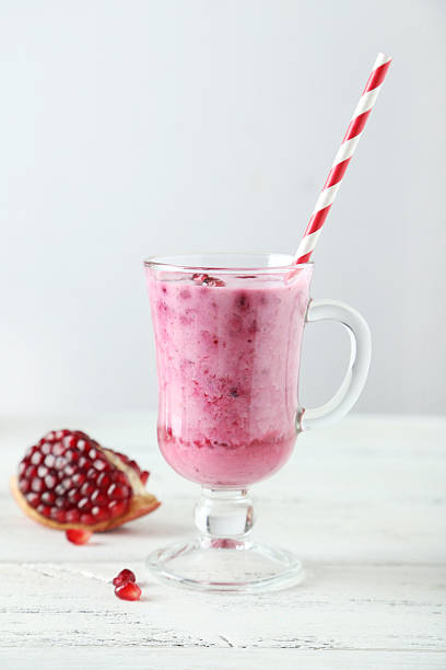 istock Pomegranate smoothie in glass on white wooden background 467220838