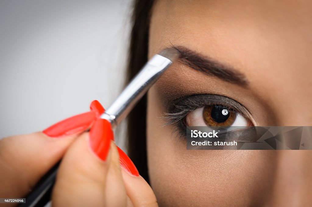 Applying perfect makeup Beautiful brunette portrait, applying perfect makeup to eyes 2015 Stock Photo